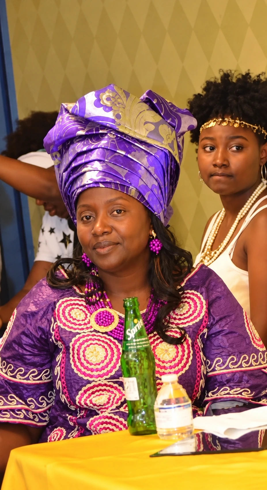 TM African Fashion founder wearing purple traditional African attire